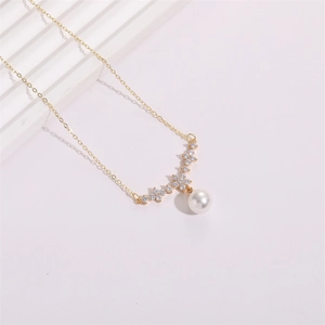 Elegant gold flower necklace with clear zircon crystals and a white pearl pendant