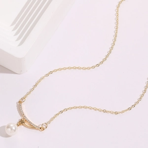 Detailed shot of golden necklace with a white pearl and sparkling star pendant decoration