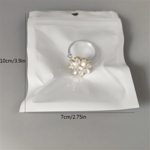 Detailed size view of the snowflake spinner ring with crystals and pearl on 10x7cm package