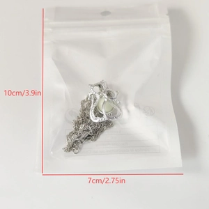 Detailansicht der silbernen Katzen-Halskette in 10x7cm Verpackung mit Maßangaben