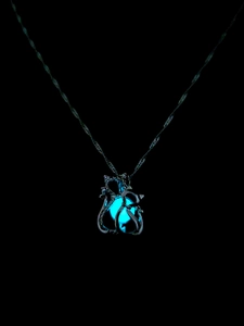 Detailansicht der leuchtend blau strahlenden Perle im katzenförmigen Metallanhänger
