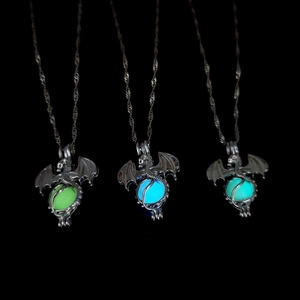 Detailed view showing three luminous dragon necklaces with green, blue, and cyan glow