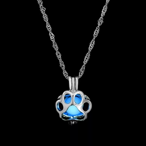 Macro view of luminous dog paw pendant necklace glowing in bright blue light