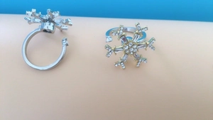 Detail view of two silver snowflake rings with adjustable band and sparkling crystals