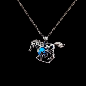 Detailed macro shot of a hollow horse pendant with a glowing blue luminous gemstone