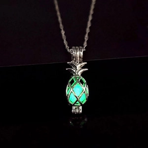 Macro shot of luminous hollow pineapple pendant necklace glowing bright green in the dark