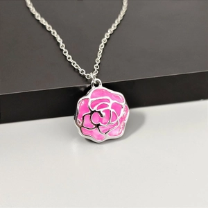 Elegante silberne Halskette mit einem rosa Emaille-Rosenanhänger auf dezentem Hintergrund