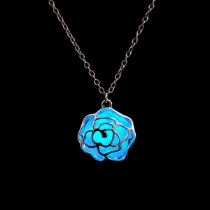 Nahaufnahme der Rosenblüten-Halskette mit blauem Leuchteffekt im Dunkeln