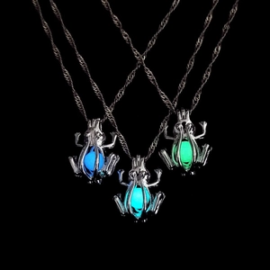 Luminous frog pendant necklace set with glowing blue and green beads in dark background