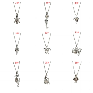 Macro detail van zilveren parelkooi hangers met zeedieren zoals schildpad en zeemeermin