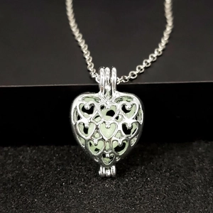 Collier avec pendentif cœur ajouré, perle lumineuse et chaîne en métal argenté
