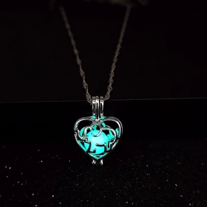 Glow in the dark heart pendant with elephant silhouette and luminous blue stone