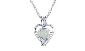 Close-up of heart pendant necklace with glowing stone and silver metal chain detail