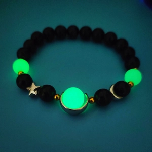 Detailed view of luminous beaded bracelet with silver star moon charms and glowing beads