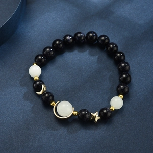 Macro detail of blue sandstone beads with golden star and moon charms on the starry bracelet