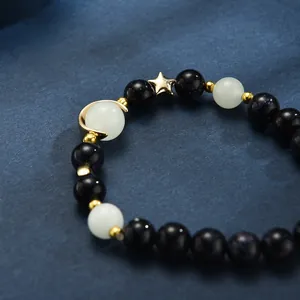 Detailed shot of dark blue goldstone beads and golden star moon charms on the bracelet
