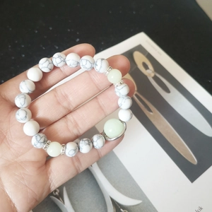 Detailaufnahme von Türkis-Perlenarmband mit Saturn-Anhänger und Silberperlen