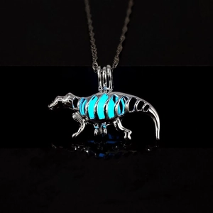 Macro shot of luminous hollow dinosaur skeleton pendant glowing blue in dark
