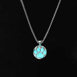 Collar con colgante de huella azul luminosa y cadena plateada en fondo negro