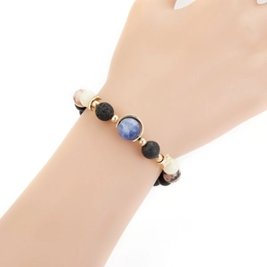Detail of galaxy themed beaded bracelet with black lava stone and star moon charms