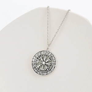 Vintage Viking Vegvisir compass pendant necklace with Nordic runes on a white podium