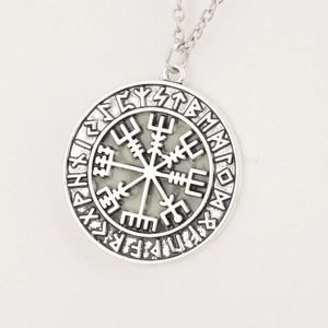 Macro detail of vintage Viking Vegvisir compass necklace with Futhark runes on silver pendant
