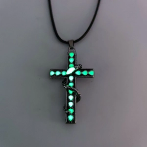 Corazón luminoso verde en cruz gótica plateada con un colgante de serpiente