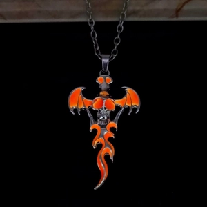 Detail of gothic skull pendant with silver wings and orange flame enamel work