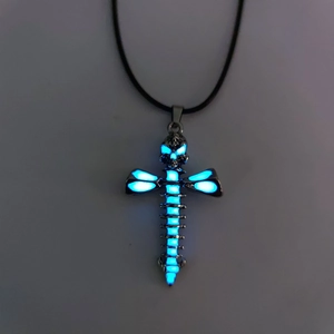 Gothic cross necklace with glowing blue skull and spine pendant in dark setting