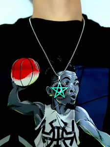 Close-up of glowing green star and crescent moon pendant on a silver chain worn by a person