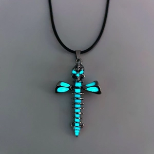 Close-up of gothic skeleton cross pendant with glowing blue luminous skull and spine