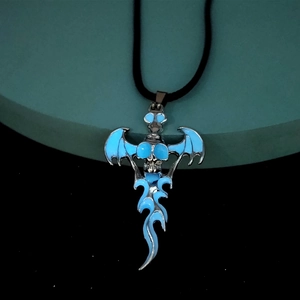 Macro shot of silver gothic skull pendant with blue wings and flame detailing on a cord