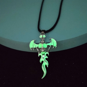 Gothic skull pendant with bat wings showing a green glowing effect in the dark