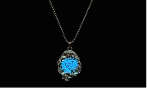 Close-up of Viking pendant showing glowing blue Nordic pattern and lava texture in the dark
