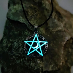 Luminous pentagram and moon necklace with celtic knot design on dark stone background