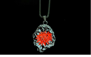 Close-up of Viking pendant with red glowing solar totem and molten silver texture