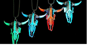 Dettaglio di quattro ciondoli a testa di toro luminosi in vari colori neon con catene
