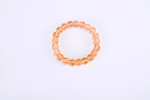 Macro view of 8mm orange sunstone beads with luminous sand texture and elastic cord