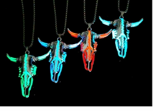 Collana con pendente a teschio di toro luminoso che mostra quattro colori in ambiente buio