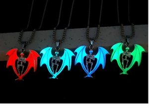 Detailed view of four glowing bat wing skull pendants in red, blue and green light