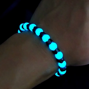 Luminous beaded bracelet glowing blue in the dark with dark magnetic spacer beads