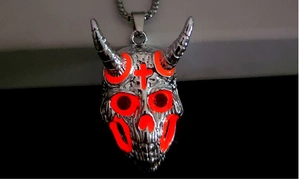 Détail macro du pendentif crâne de bélier argenté avec yeux lumineux et croix