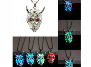 Détail d'un pendentif tête de bélier luminescent brillant en bleu et vert la nuit