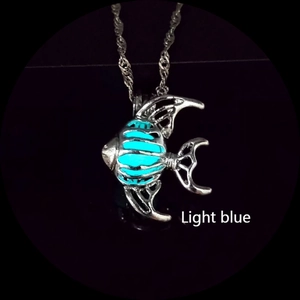 Détail d'un pendentif en forme de poisson avec effet lumineux bleu clair et chaîne argent