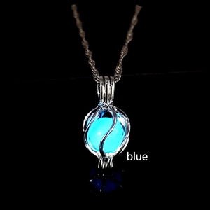Detailed view of glow-in-the-dark blue fluorite sphere inside a planet metal cage pendant