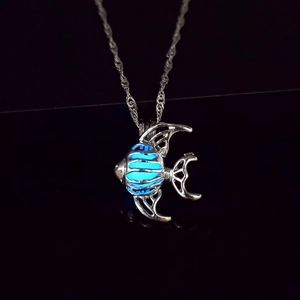 Collier poisson tropical lumineux avec pierre bleue brillante dans le noir