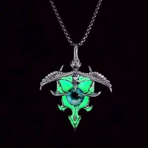 Close-up of a glowing green luminous eyeball pendant with silver punk design