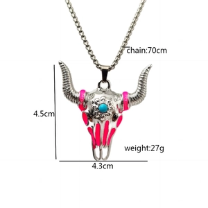 Detail of vintage bull skull necklace with pink enamel stripes and turquoise bead accent