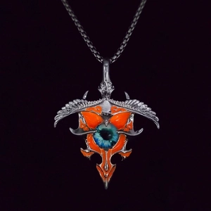 Close-up of punk eagle wing pendant with realistic blue eye and orange enamel details