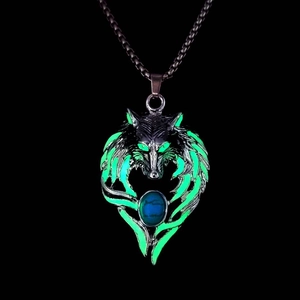 Detail of glow in the dark wolf head pendant with green luminous eyes and turquoise stone
